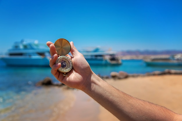 Compass in hand against the sea