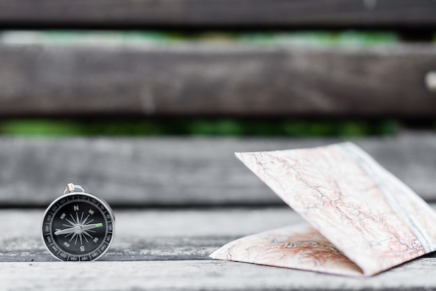 Compass and map on a beautiful wooden surface. Top view