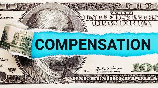 Compensation word written on with American Dollarbills Salary and wages concept The word Compensation on dollar usa background Finance and money concept