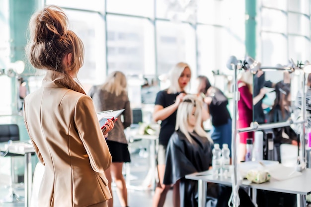 Competition stylists hairdressers at the exhibition of hairstyles and makeup The judge looks at the result and evaluates the hairstyle