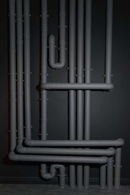 Complicated Gray plastic drainage pipes system on wall