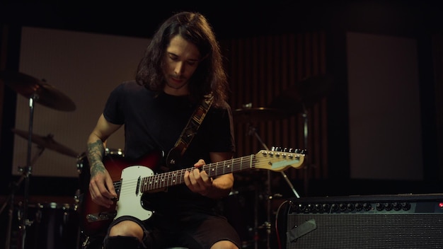 Composer playing song in concert hall Guitarist rehearsing in recording studio