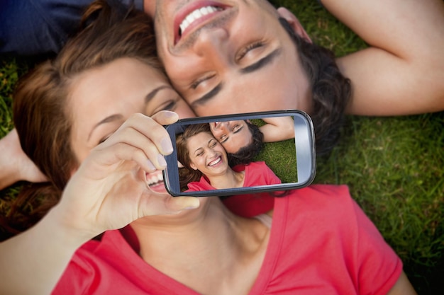 Composite of Couple taking selfie on smartphone