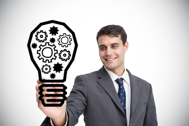 Composite image of businessman drawing light bulb against white background with vignette