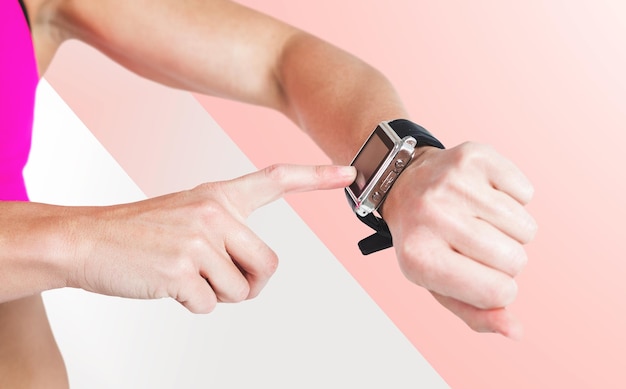 Composite image of female athlete using her smart watch