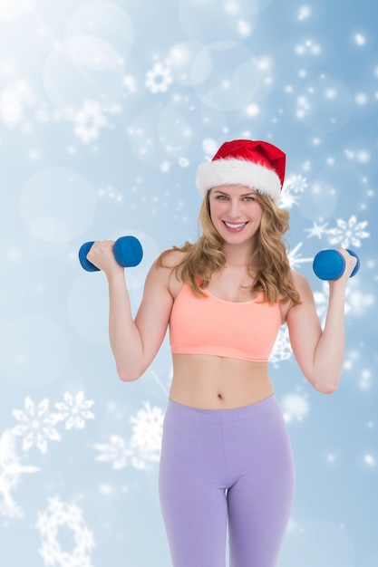 Composite image of festive fit blonde holding dumbbells