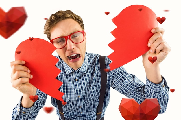 Composite image of geeky hipster holding a broken heart