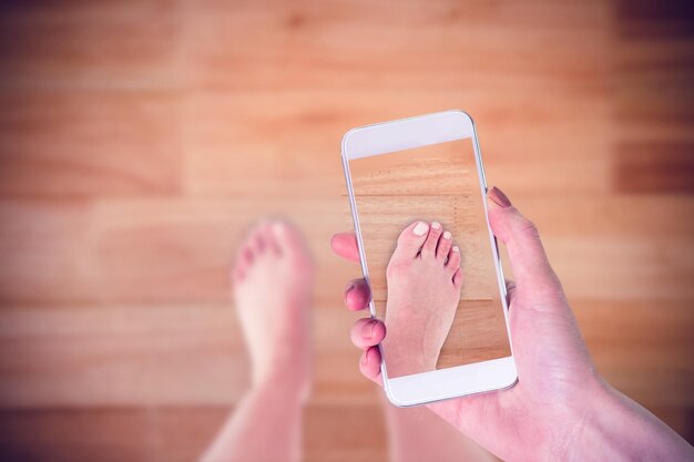 Composite image of hand holding smartphone