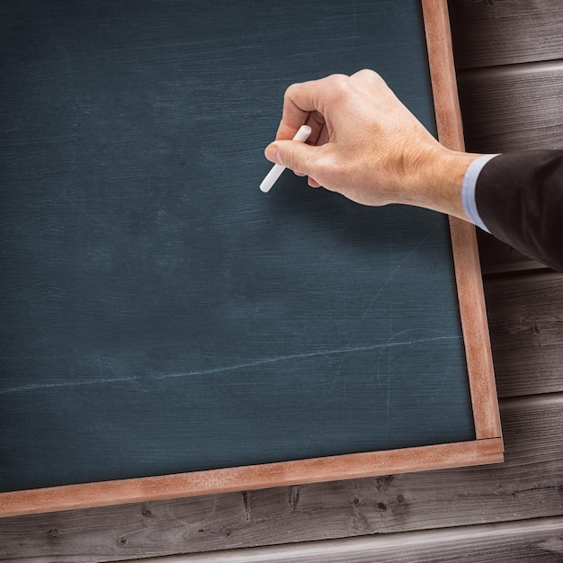 Composite image of hand writing with a white chalk