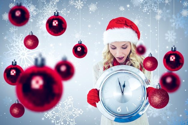 Composite image of happy festive blonde with clock