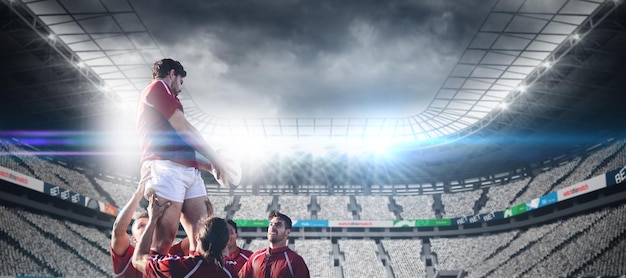 Composite image of male rugby players playing rugby in the ground