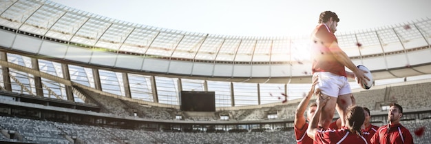 Composite image of male rugby players playing rugby in the ground