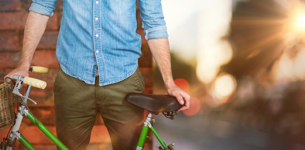 Composite image of portrait of hipster standing with bicycle