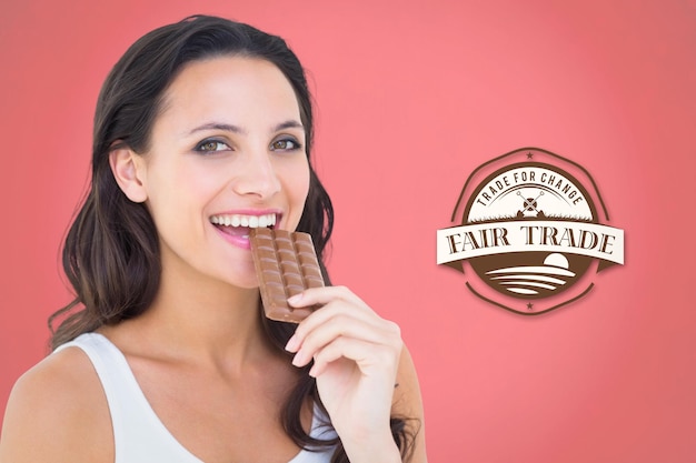 Composite image of pretty brunette eating bar of chocolate