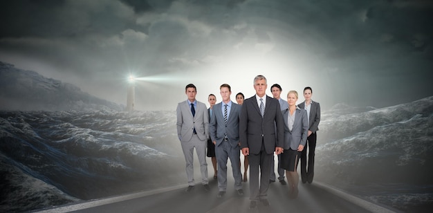 Composite image of smiling business team looking at camera