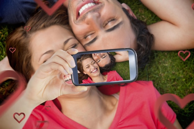 Composite image of valentines couple taking a selfie