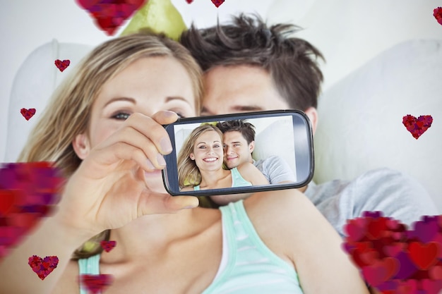 Composite image of valentines couple taking a selfie