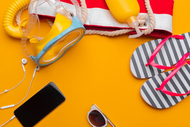 Composition of beachwear and accessories on a yellow background