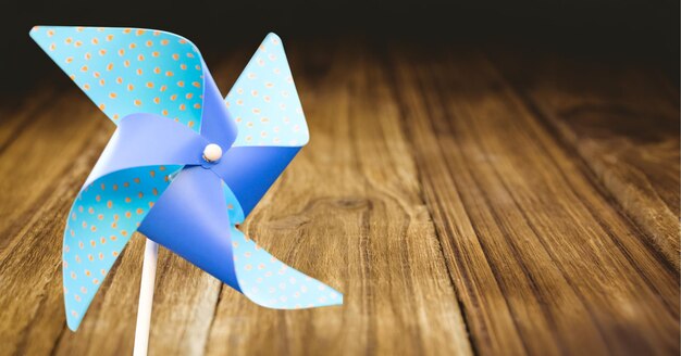 Composition of blue windmill over wooden table