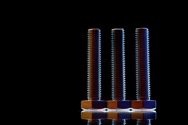 Composition of bolts and nuts of different sizes on a black background