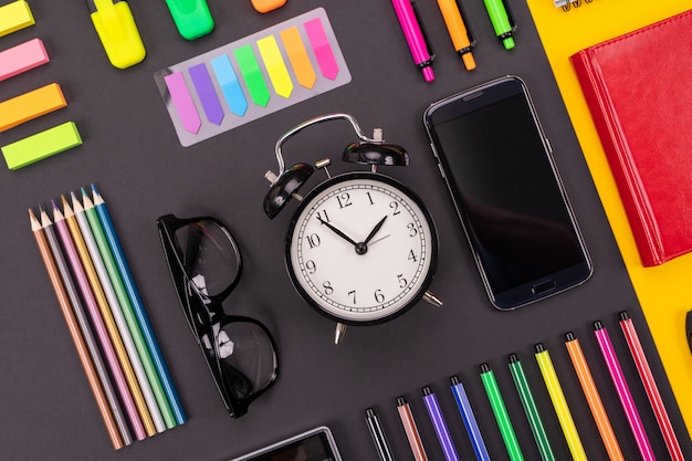 composition of business desk with alarm clock, smartphone, notebook, stickers