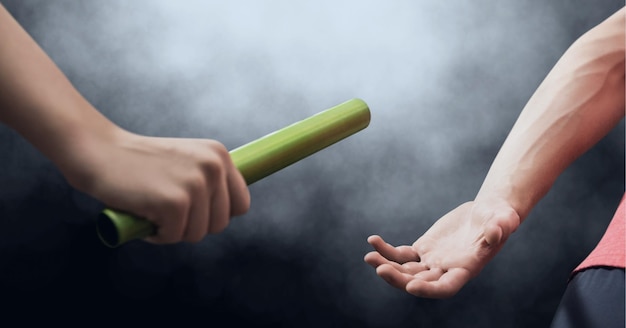 Composition of caucasian male runner passing baton to his teammate on black background