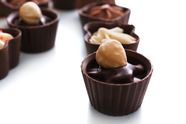 Composition of chocolate candies on white background, close up