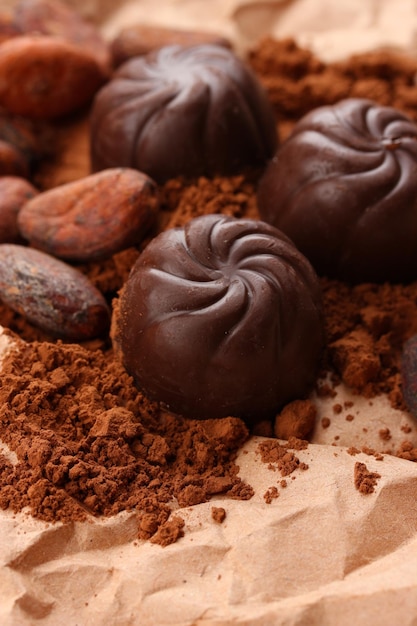 Composition of chocolate sweets and cocoa on brown background