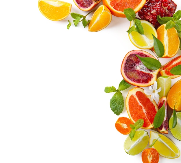 Composition of citrus fruits and green leaves on white background