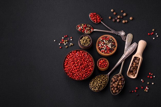 Composition concept consisting of several types of different colors of allspice in bowls and spoons