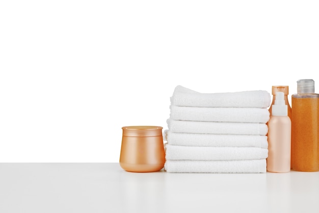 Composition of cosmetic bottles and towels isolated on white