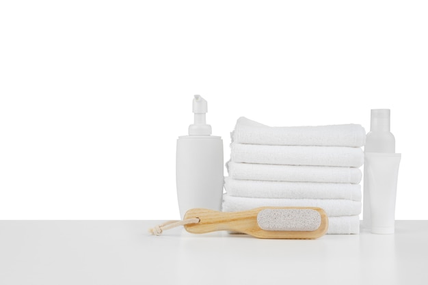 Composition of cosmetic bottles and towels isolated on white