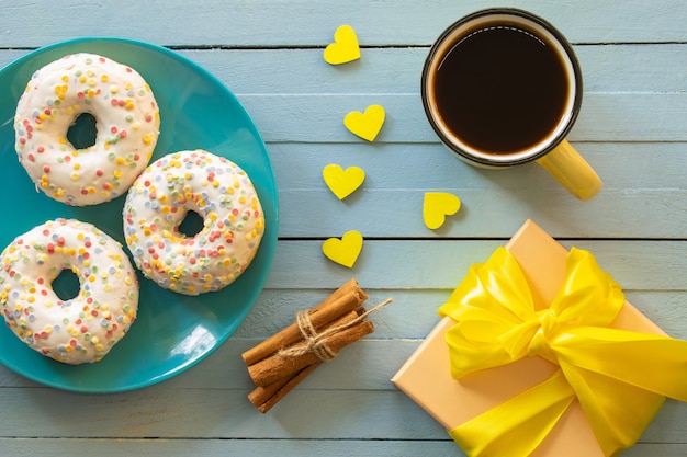 composition a cup of coffee and donuts breakfast on a wooden background