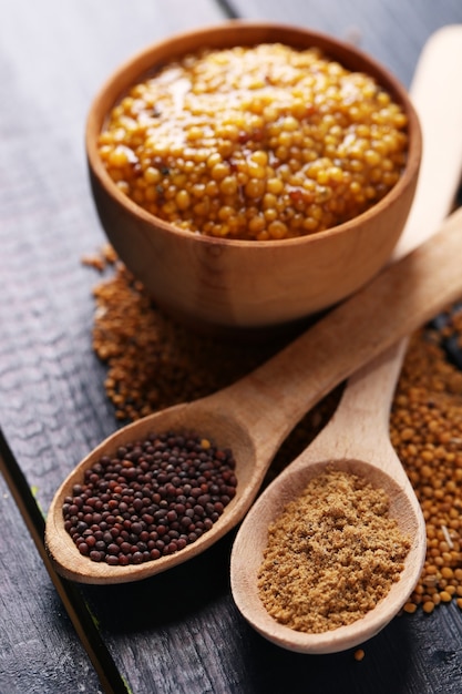 Composition of different kinds of mustard on color wooden table