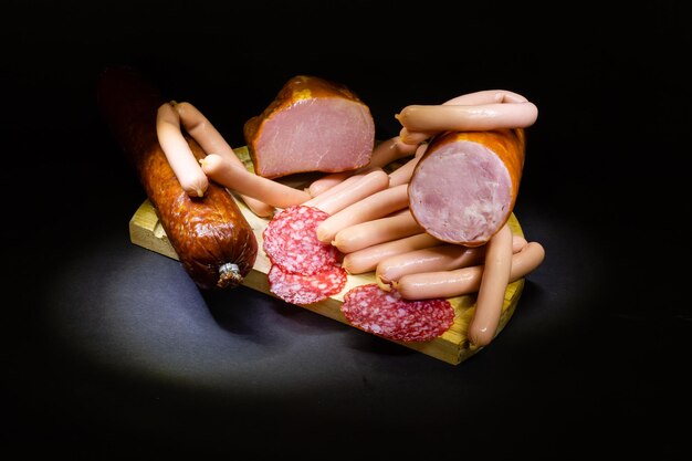 A composition of different sorts of sausages on dark background