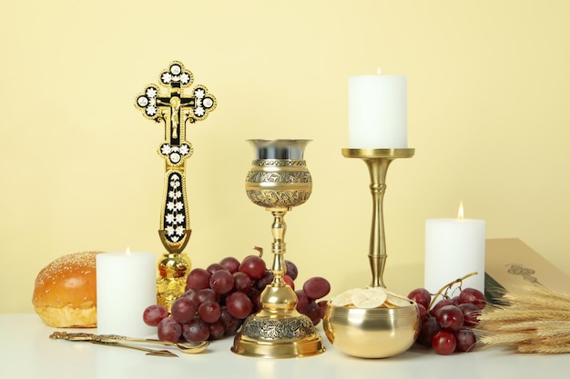 Composition of Eucharist on white table against beige background