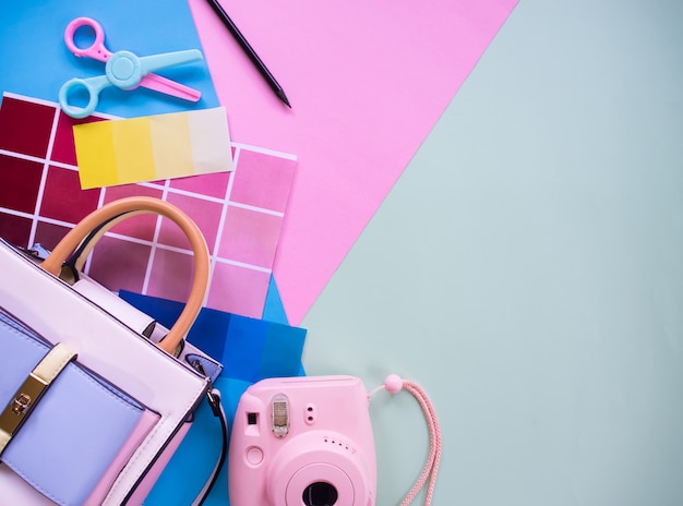 Composition of female graphic designer elements: color scheme, photo camera, scissors and colored paper with copyspace background