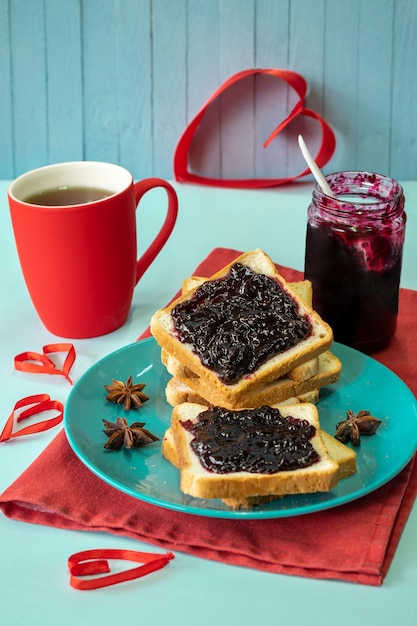 composition of a festive breakfast tea and toast with jam on a wooden background