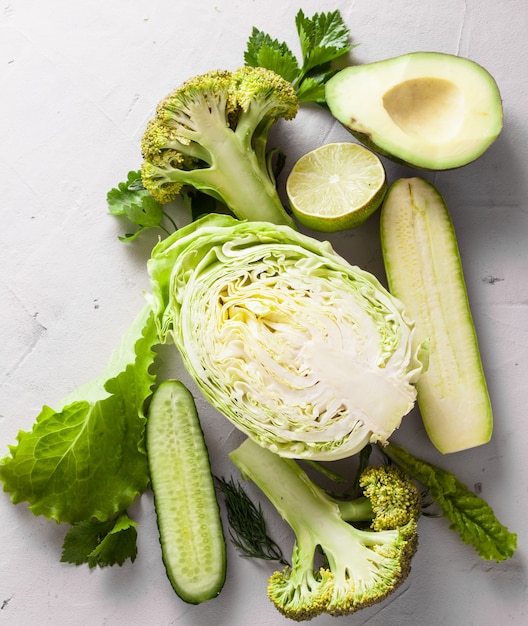 Composition of fresh green cut in half vegetables on a white background