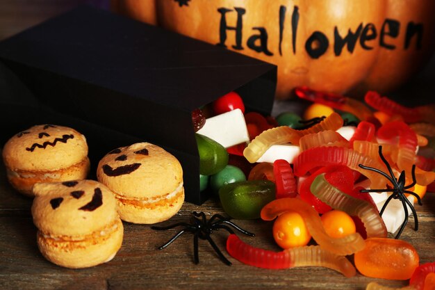 Composition for Halloween with sweets on wooden table