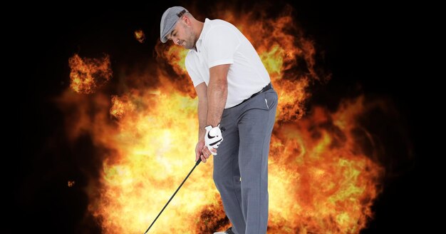 Composition of male golf player over flames on black background