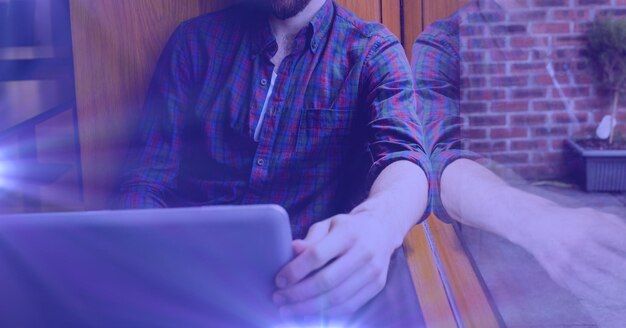 Composition of male student using laptop with blue glow