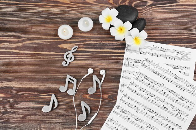 Composition of music sheets and spa supplies on wooden background