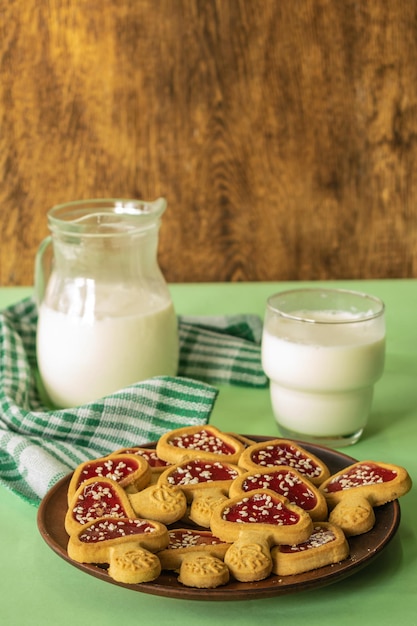 composition of rustic breakfast milk in a jug and cookies a glass of milk on a wooden background