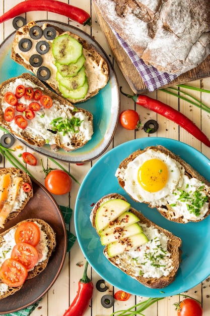 Composition sandwiches with vegetables salmon and egg on a wooden background proper nutrition