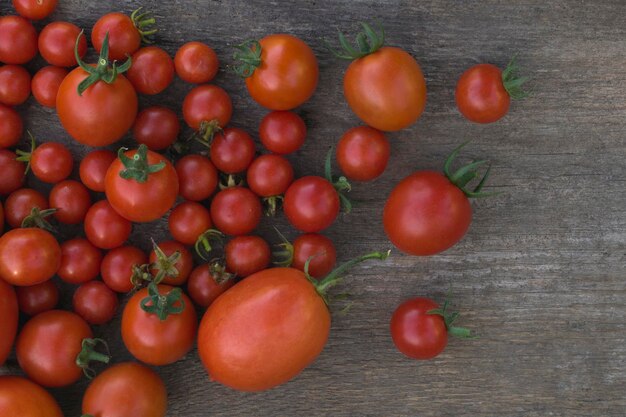 Composition of small red tomatoes with wooden background for text