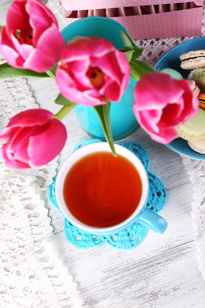 Composition of spring flowers tea and cookies on table closeup