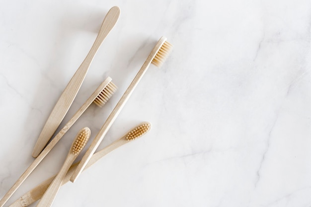 Composition with biodegradable bamboo toothbrushes on marble background. Sustainable, zero waste, plastic free, lifestyle concept. Eco-friendly oral hygiene accessories.Flat lay, top view, copy space.