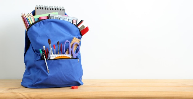 Composition with a blue backpack and school supplies