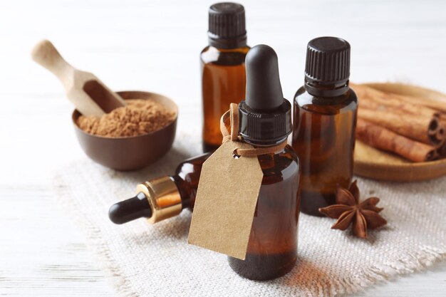 Composition with bottles of cinnamon oil on wooden background